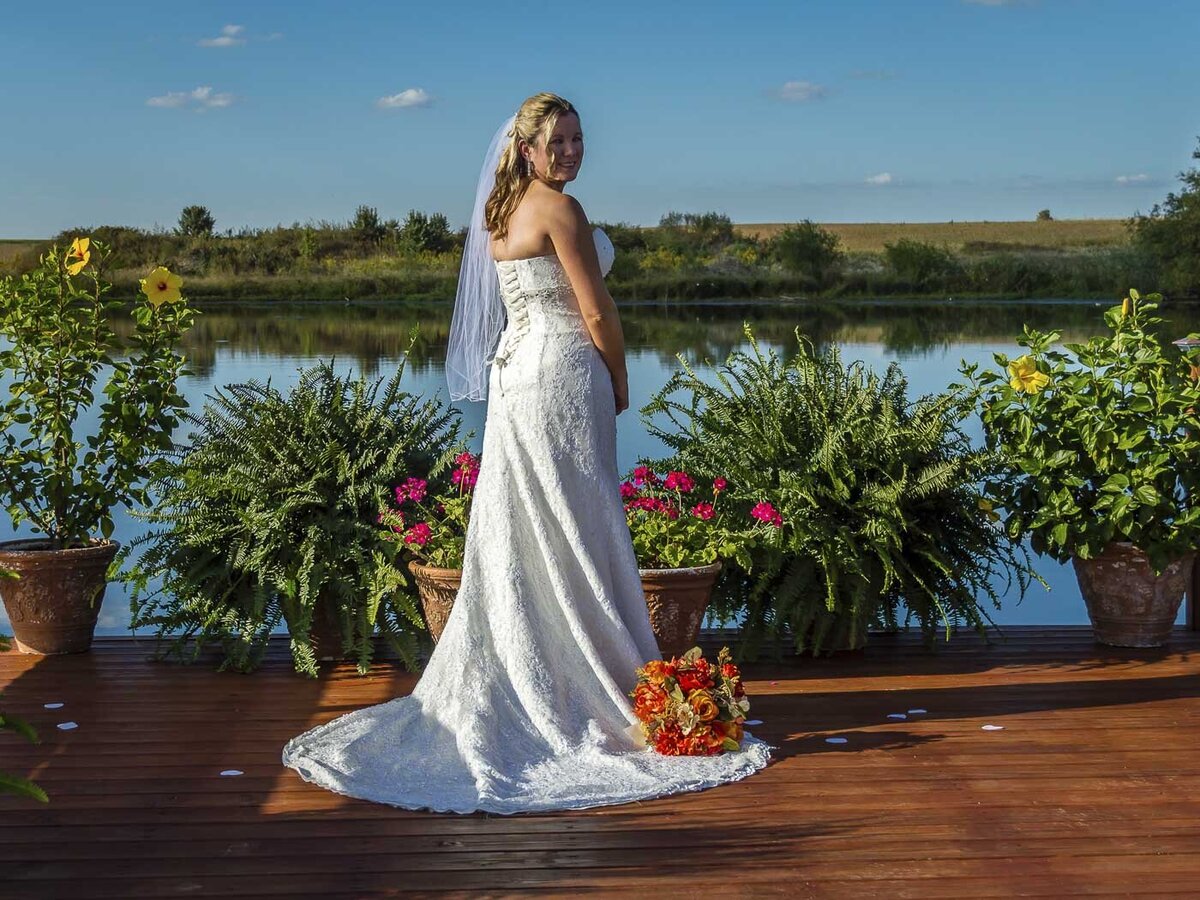 A bride poses on a dock for her bridal portrait
