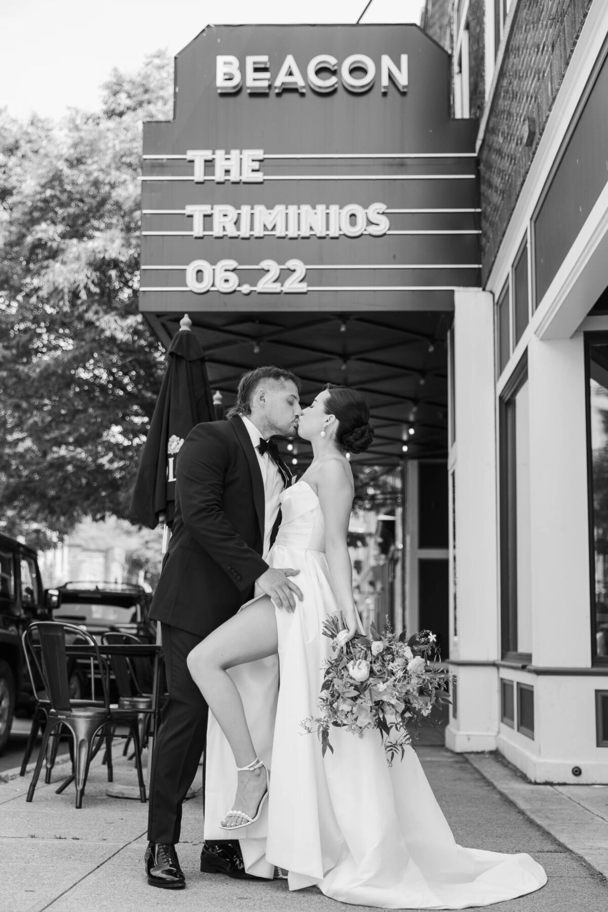 Bride and groom pose in front of Wonderbar Beacon with a custom marquee sign