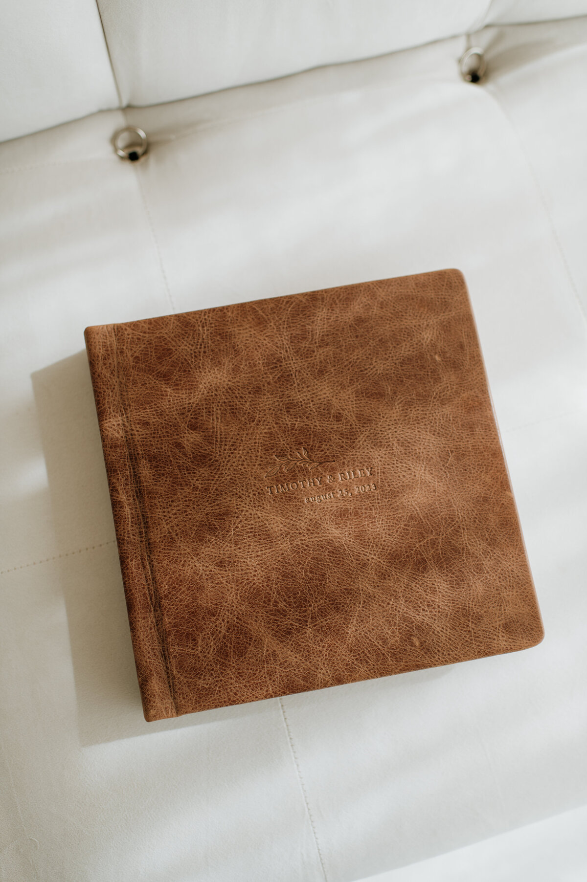 Brown leather wedding album on table