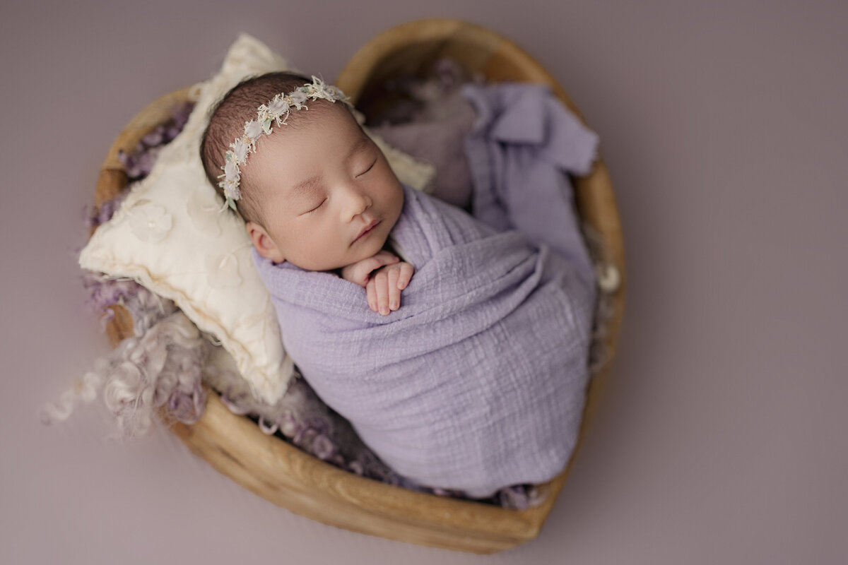 baby in purple heart basket
