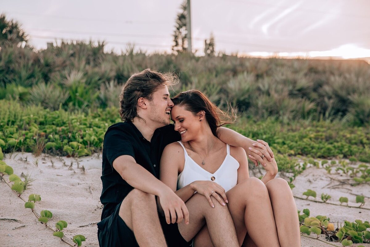 couple laughing and sitting side-by-side at ormond beach