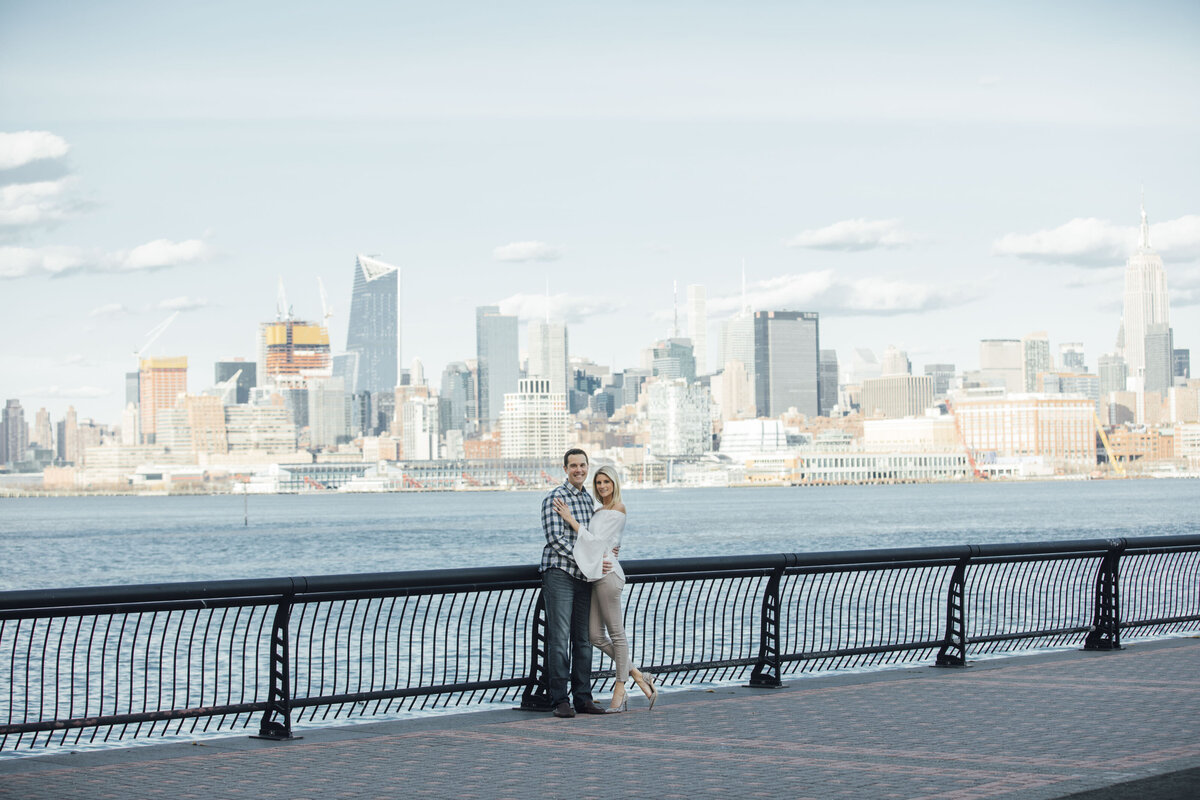 Couple with NYC skyline during summer engagement photo in Hoboken New Jersey