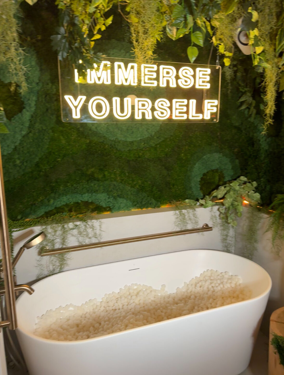 bath tub set up with grass on the wall for brand activation event