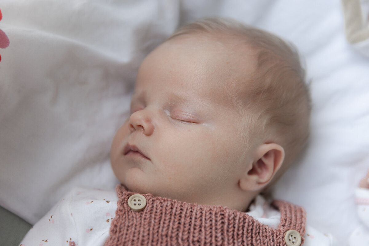 Livsstilsfoto nærbilde av sovende baby iført strikkeselebukse.