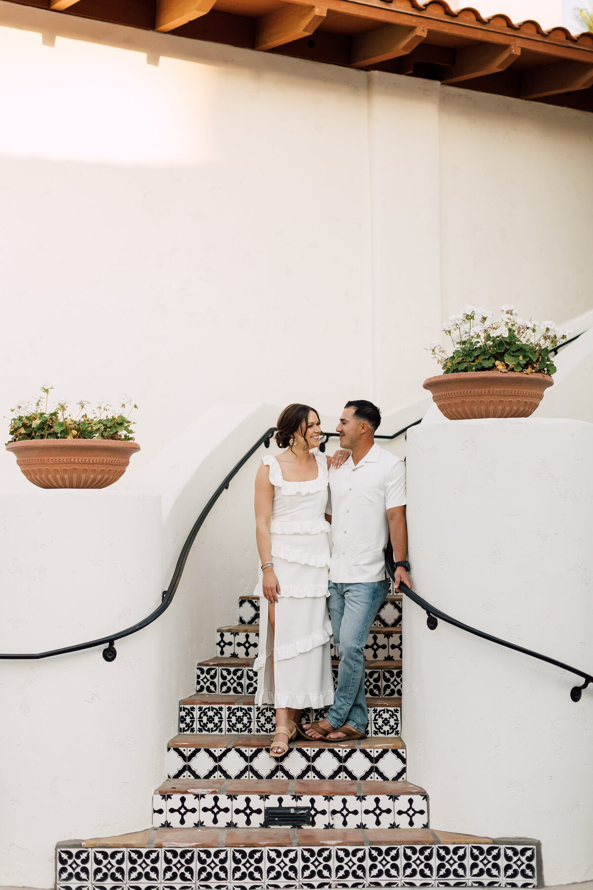 A couple sharing a candid moment as they walk down a staircase during an engagement session, captured by a Scottsdale wedding photographer.