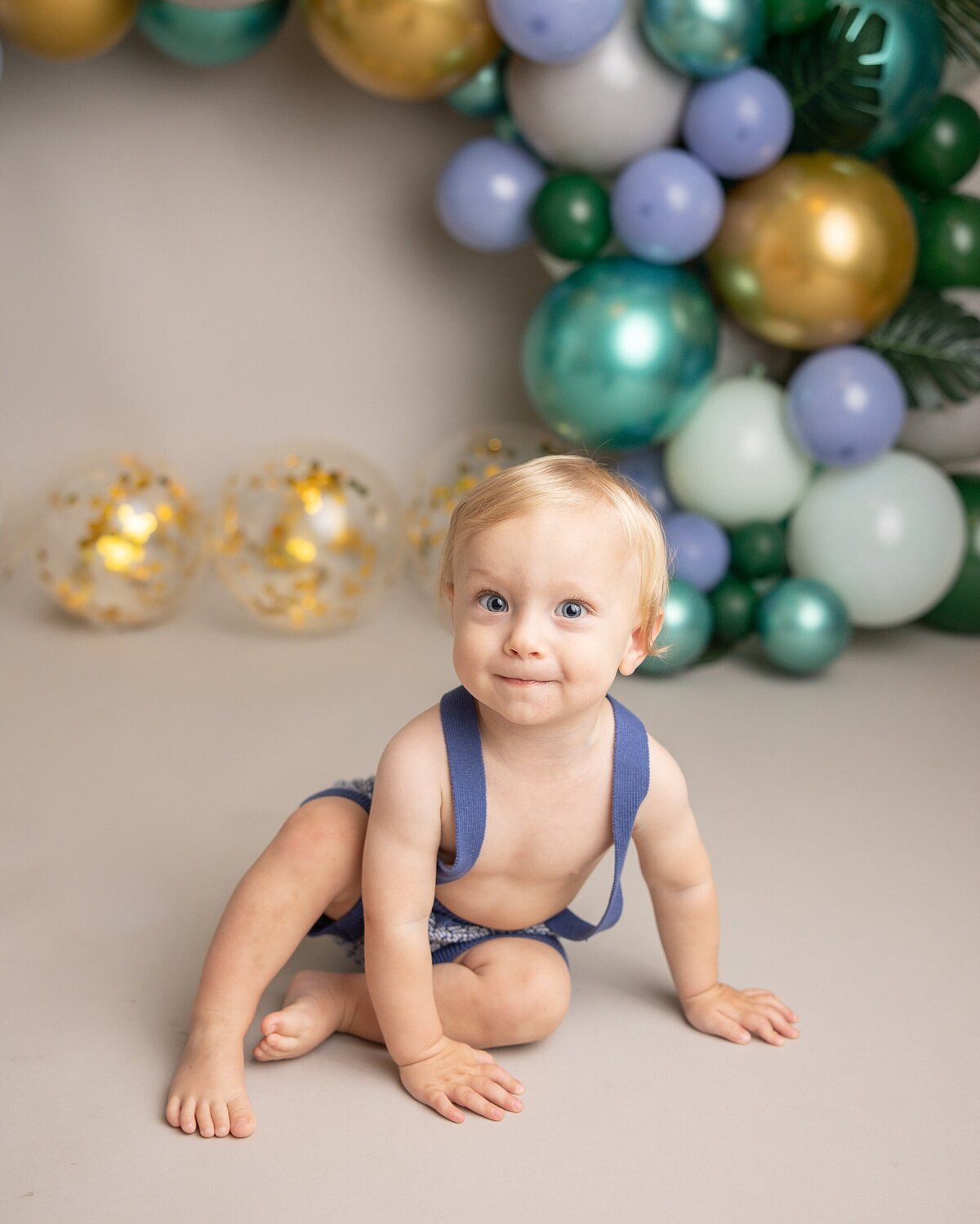 smiling baby boy about to crawl away in milestone photography session in portland oregon
