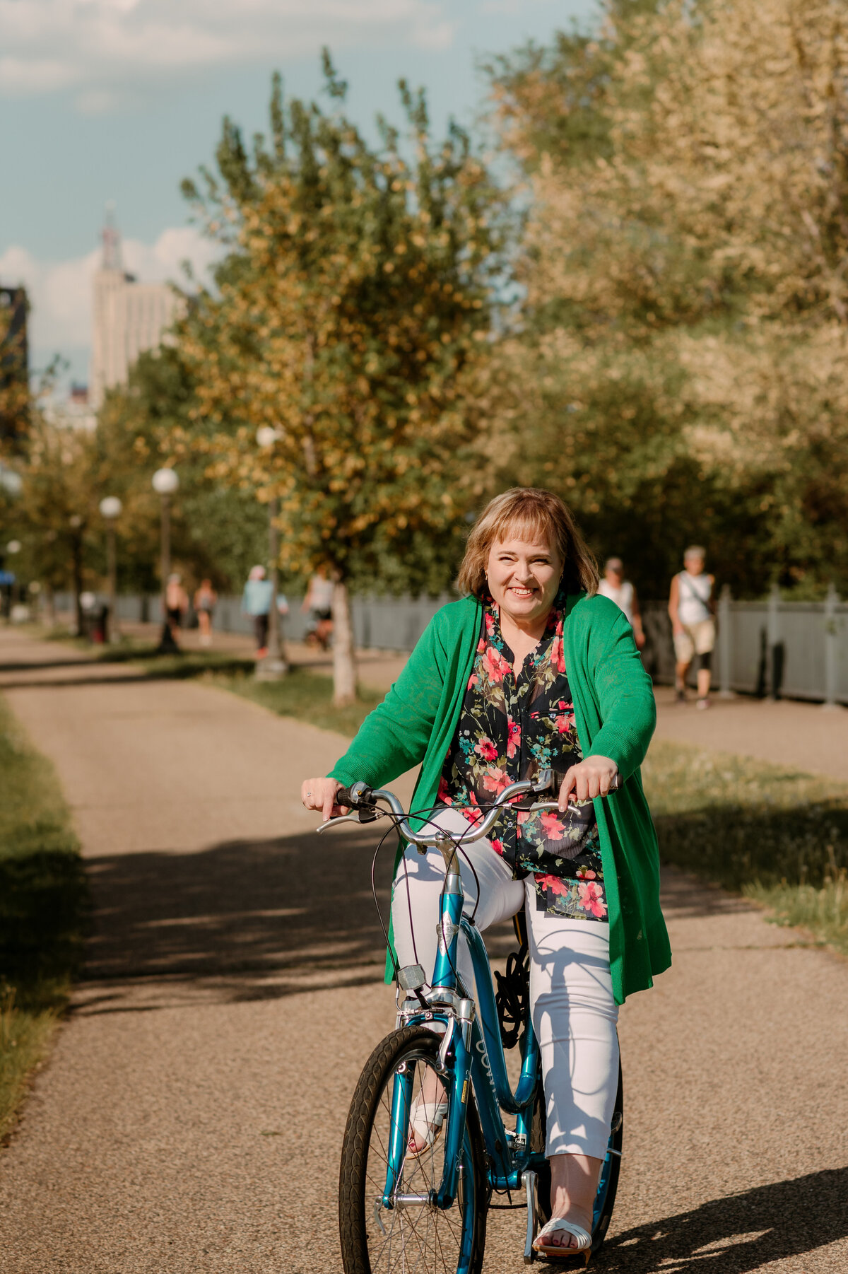 Active woman in her 50s riding a bicycle along Minneapolis river trails during lifestyle dating photo session
