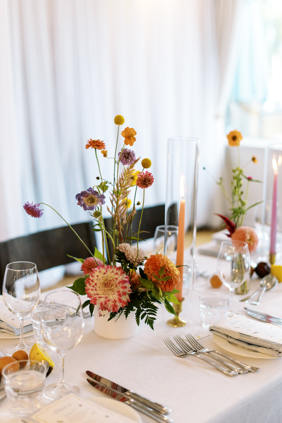 Colourful, modern centrepieces line an elegant table at a wedding reception at the Willow Inn.