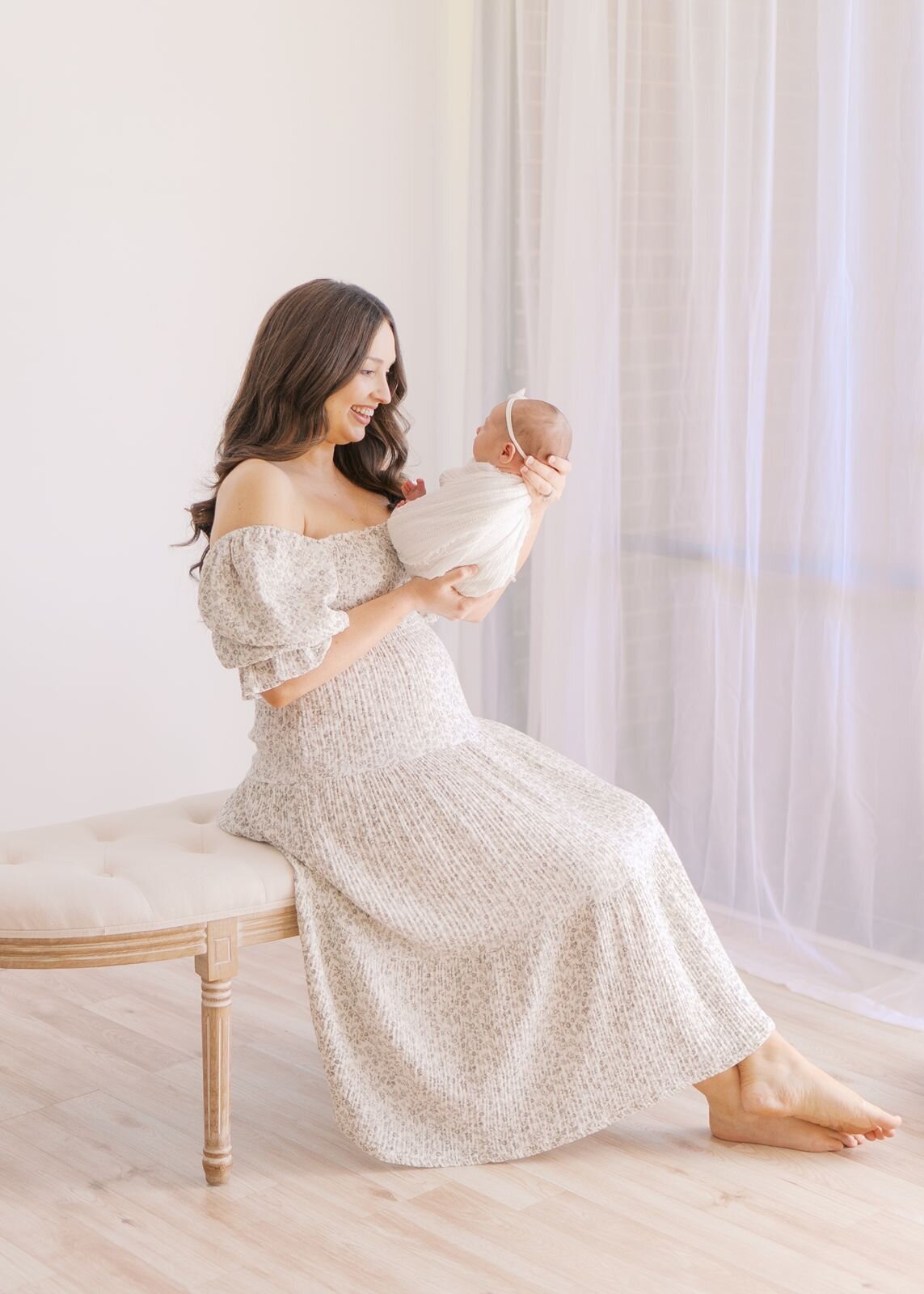 Mother smiling at newborn baby at Dallas Newborn Photography studio