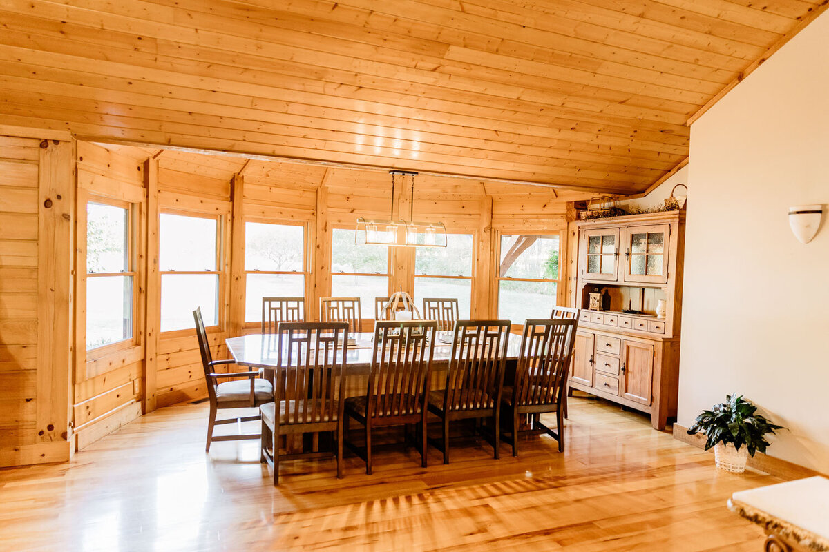 Large dining table with wooden chairs in a bright, open room