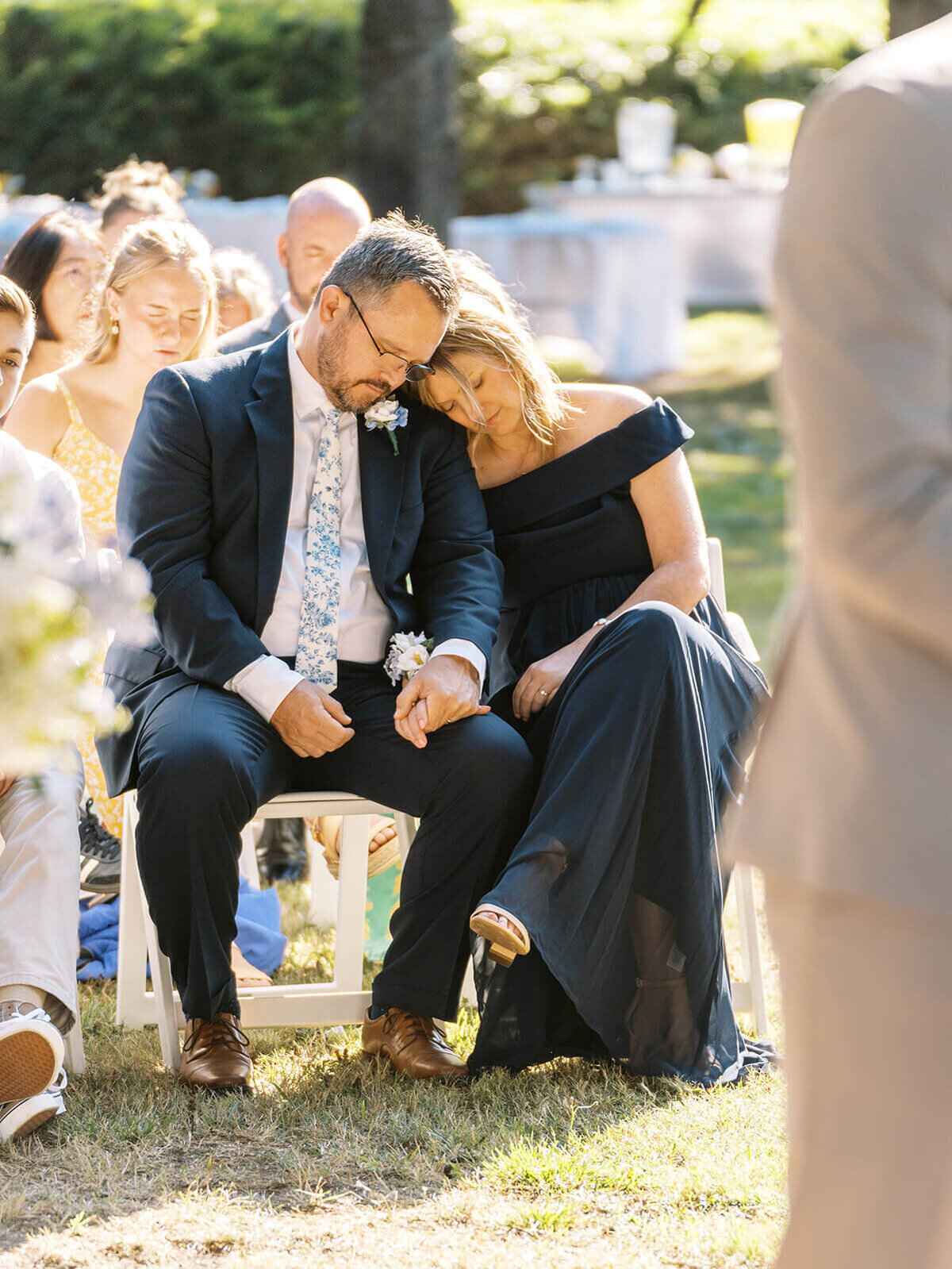 A couple sitting and leaning on each other at a wedding ceremony in Bandon, Oregon