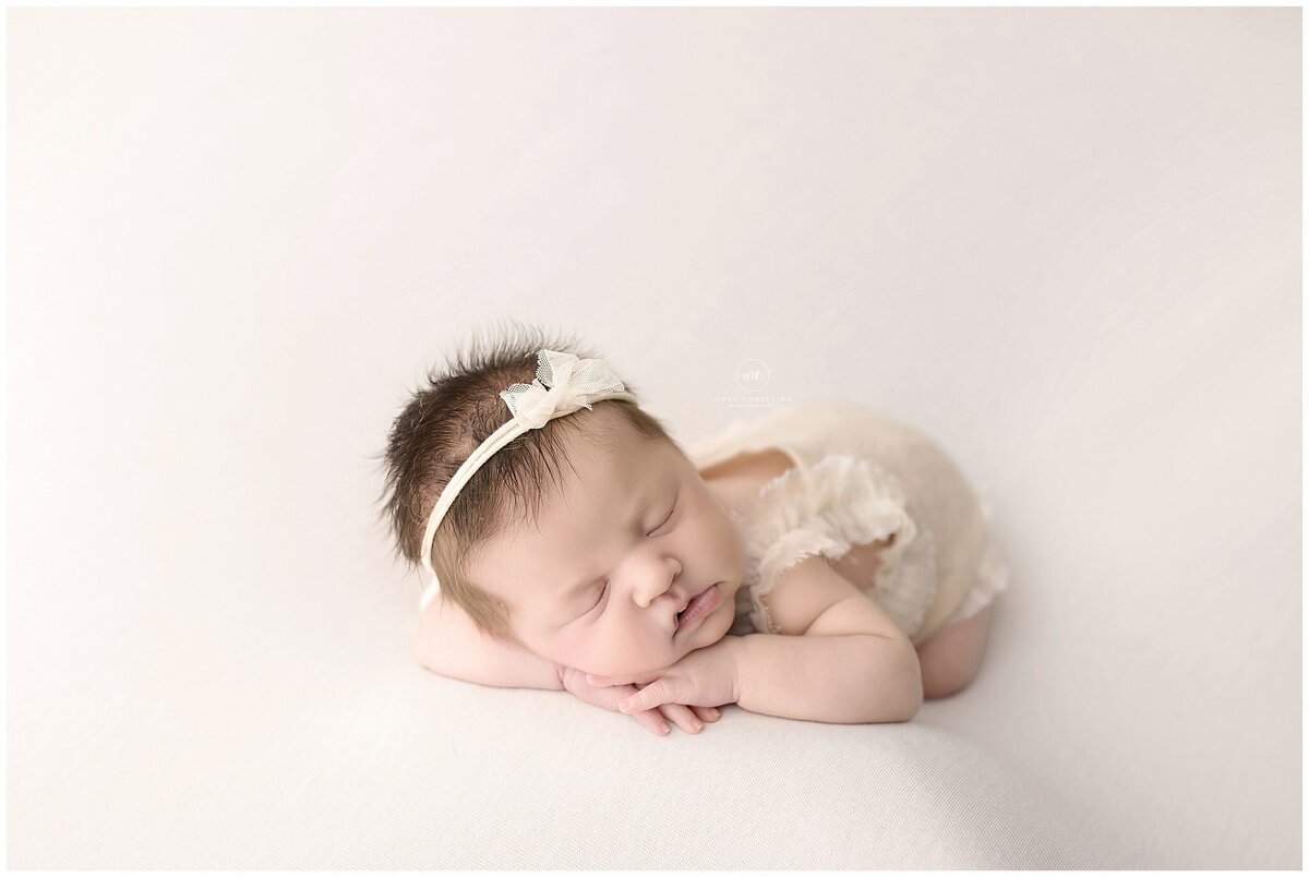 An Akron newborn photographer poses baby for portrait