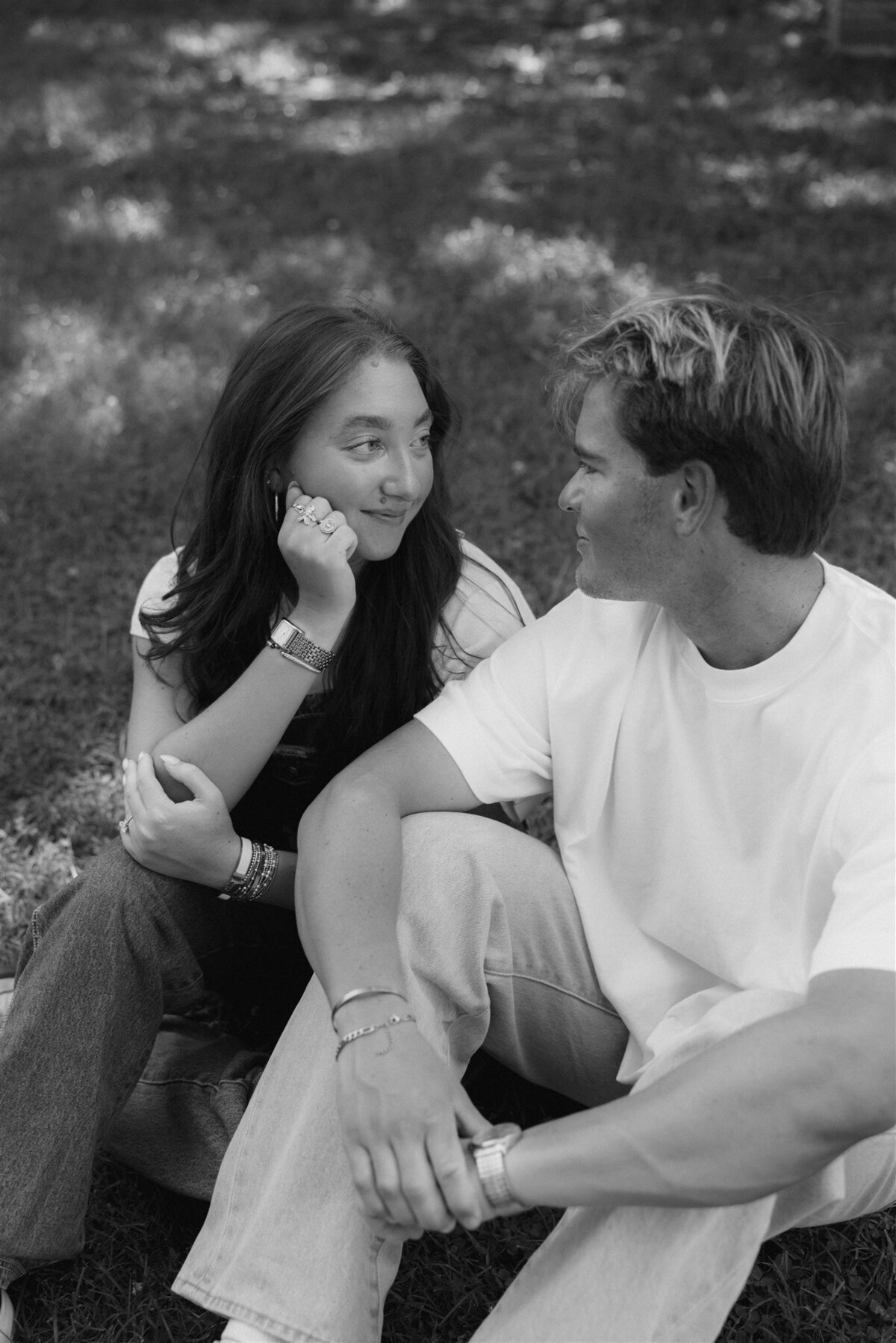 black and white couple sitting in grass smiling