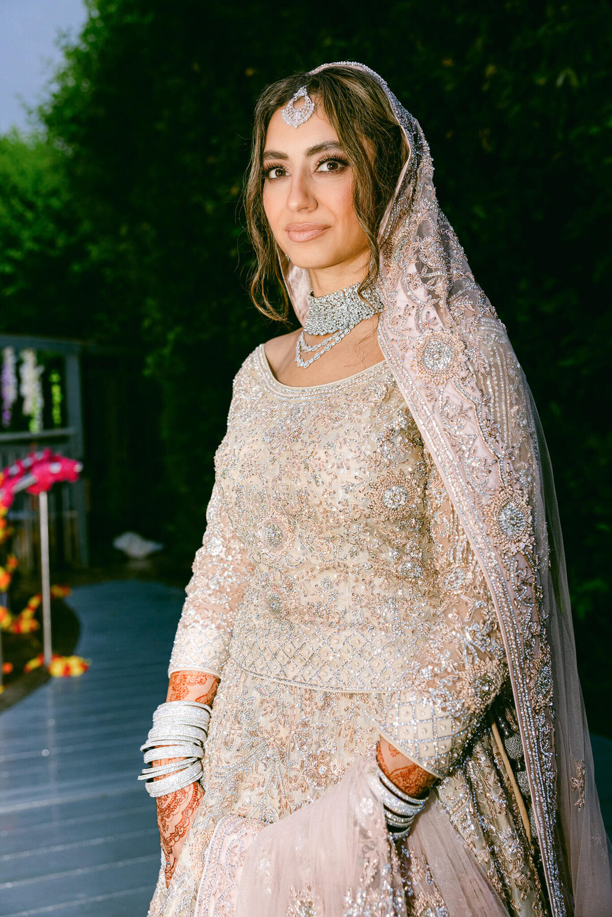 A wedding photo showing off the brides dress and jewelery as she smiles at the camera in Dublin Ireland