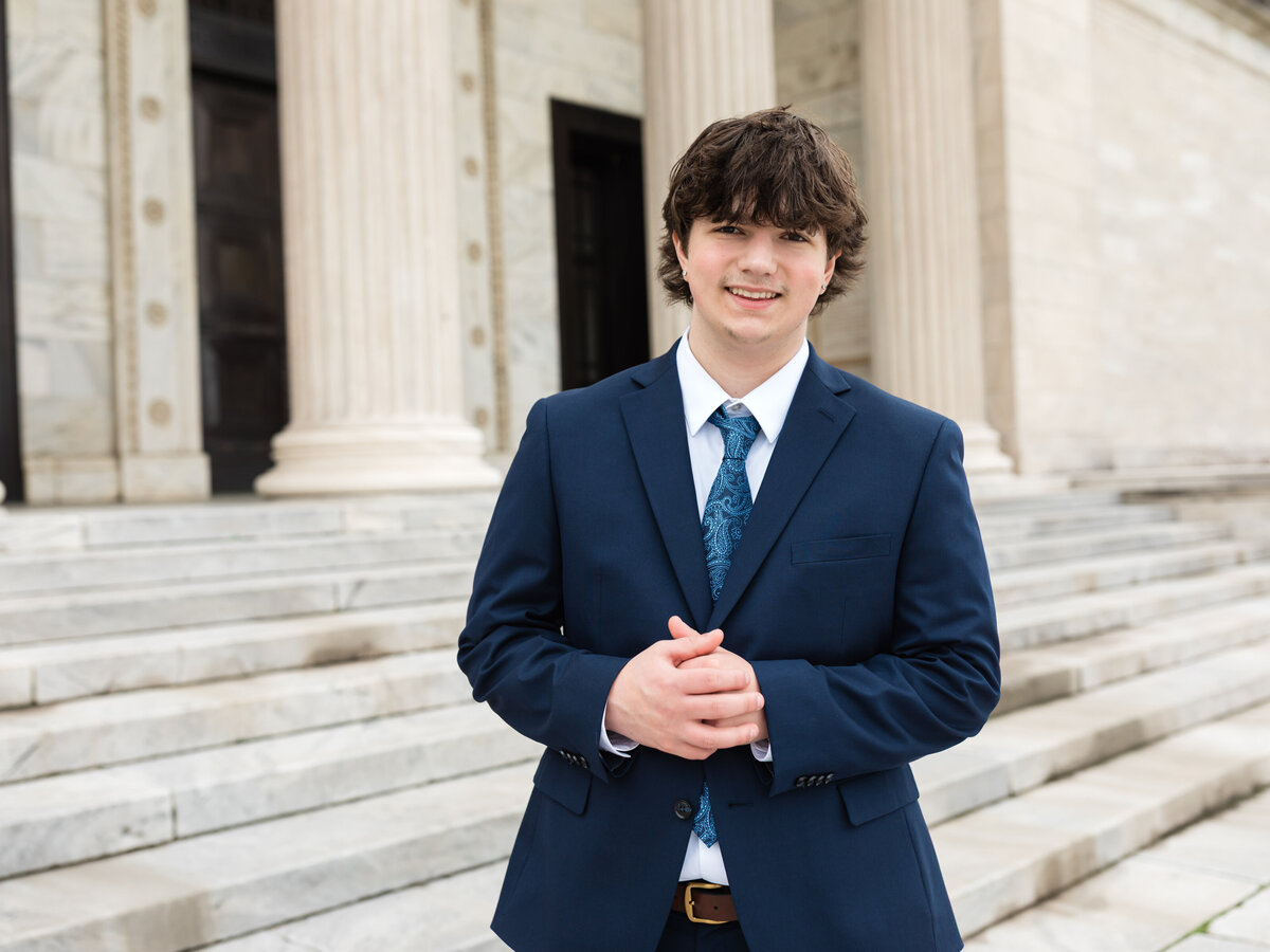 high school senior boy in blue suit posed at Cleveland Museum of Art for portraits Cleveland senior photographer