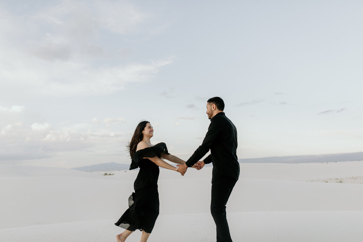engaged couple spinning together at white sands national park
