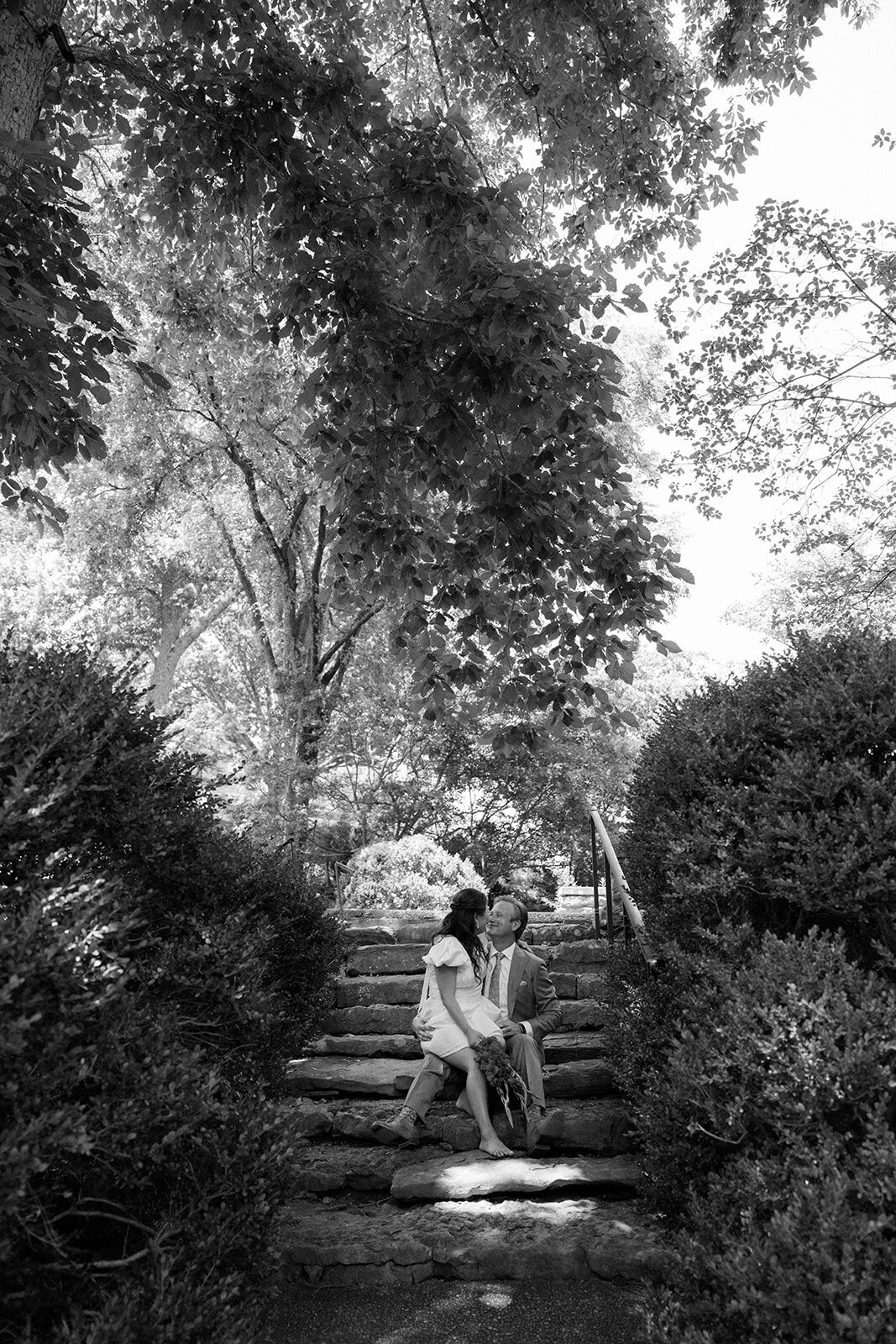 Bride and groom cozy up on a stone staircase in the middle of Cheekwood Gardens in Tennessee.