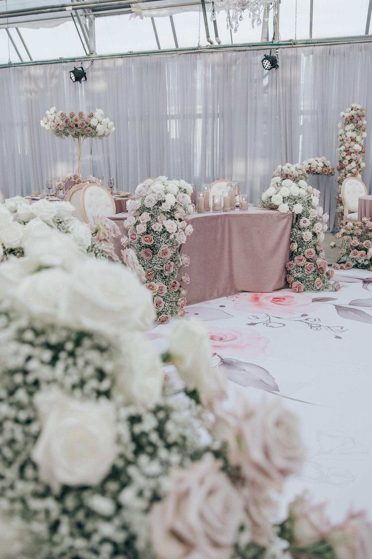 Luxurious roses spilling over head table at luxurious wedding