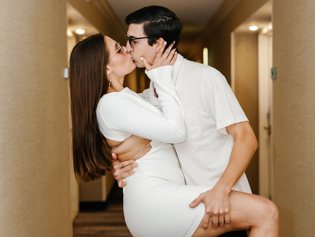 Graysen lifts Rebecca in a playful embrace inside the hotel hallway, celebrating their engagement in a fun and romantic way at Marriott Hotel Fort Lauderdale.