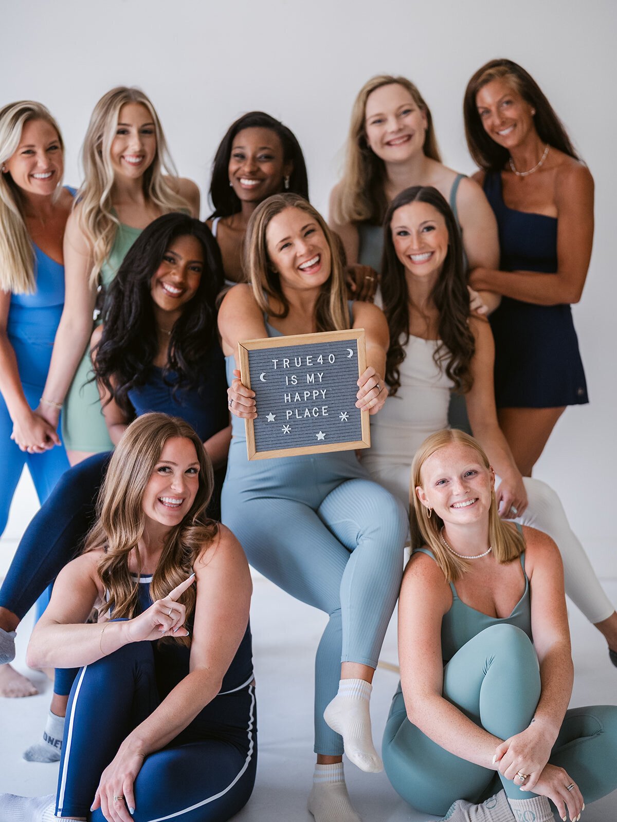 Group of women holding a wood sign that says true40 is my happy place 