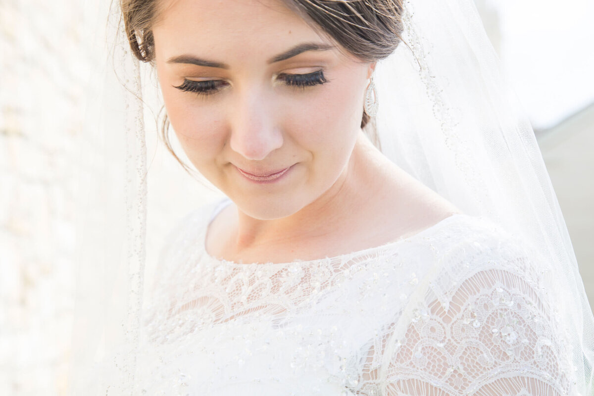 bride looking down in a lace dress on beautiful utah wedding day