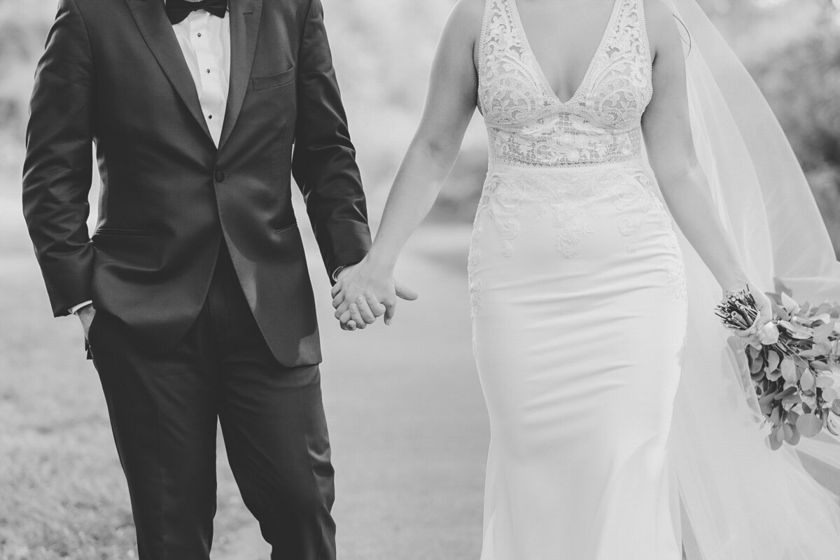 Bride and groom holding hands while walking
