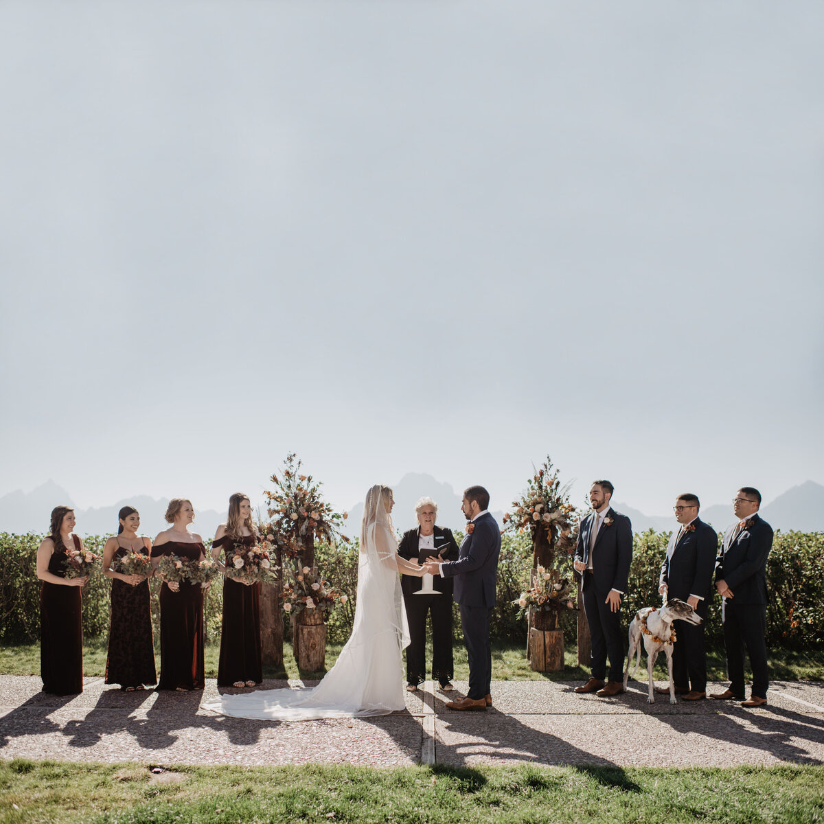 Photographers Jackson Hole capture bride and groom holding hands at Grand Teton wedding ceremony