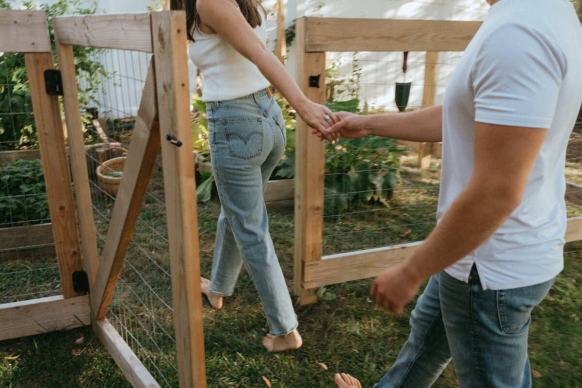 couple walking in garden during at home engagement photos, captured by Elsie Goodman, an NYC engagement and couples photographer