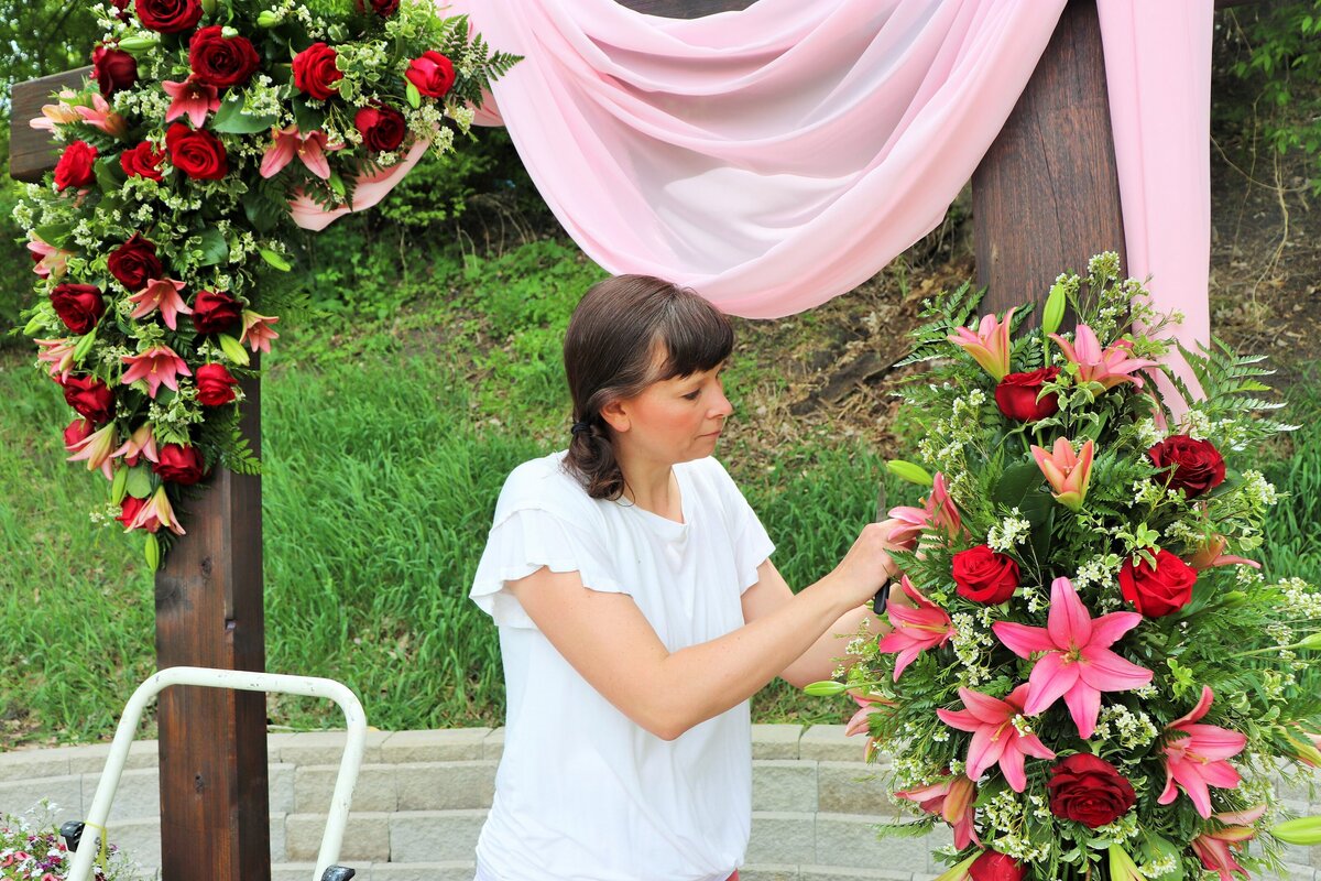 florist-arranging-flowers-on-arch