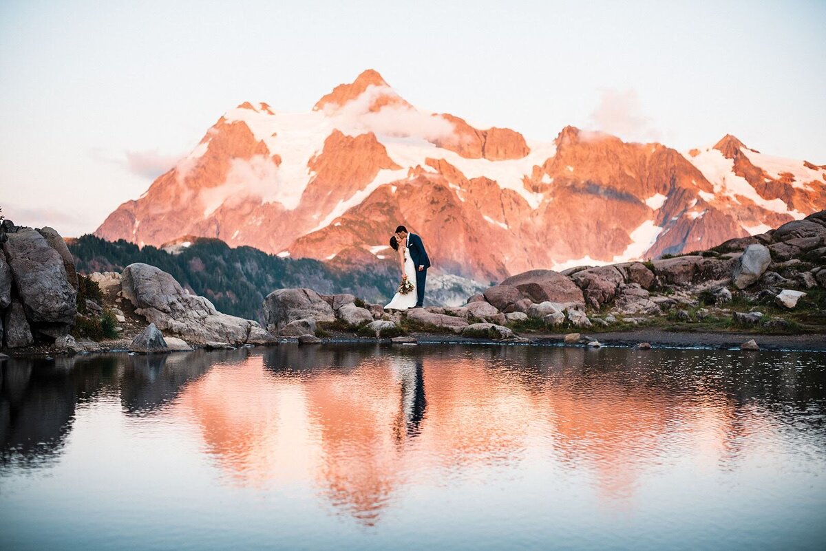 Bride & groom kissing in front of a pink Mount Skuksan in the North Cascades at sunset!