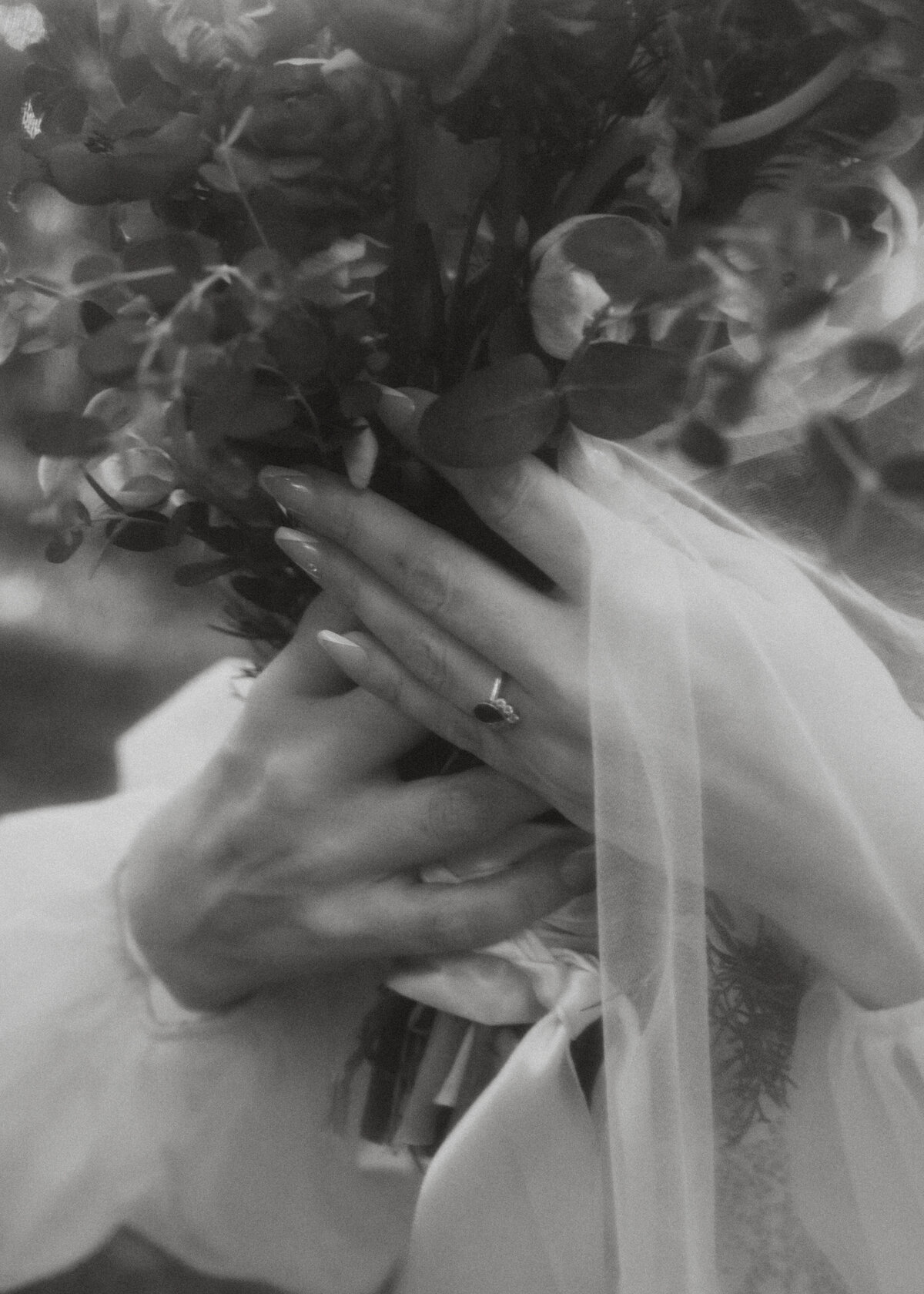 Bride holding her bouquet with ring and veil on display