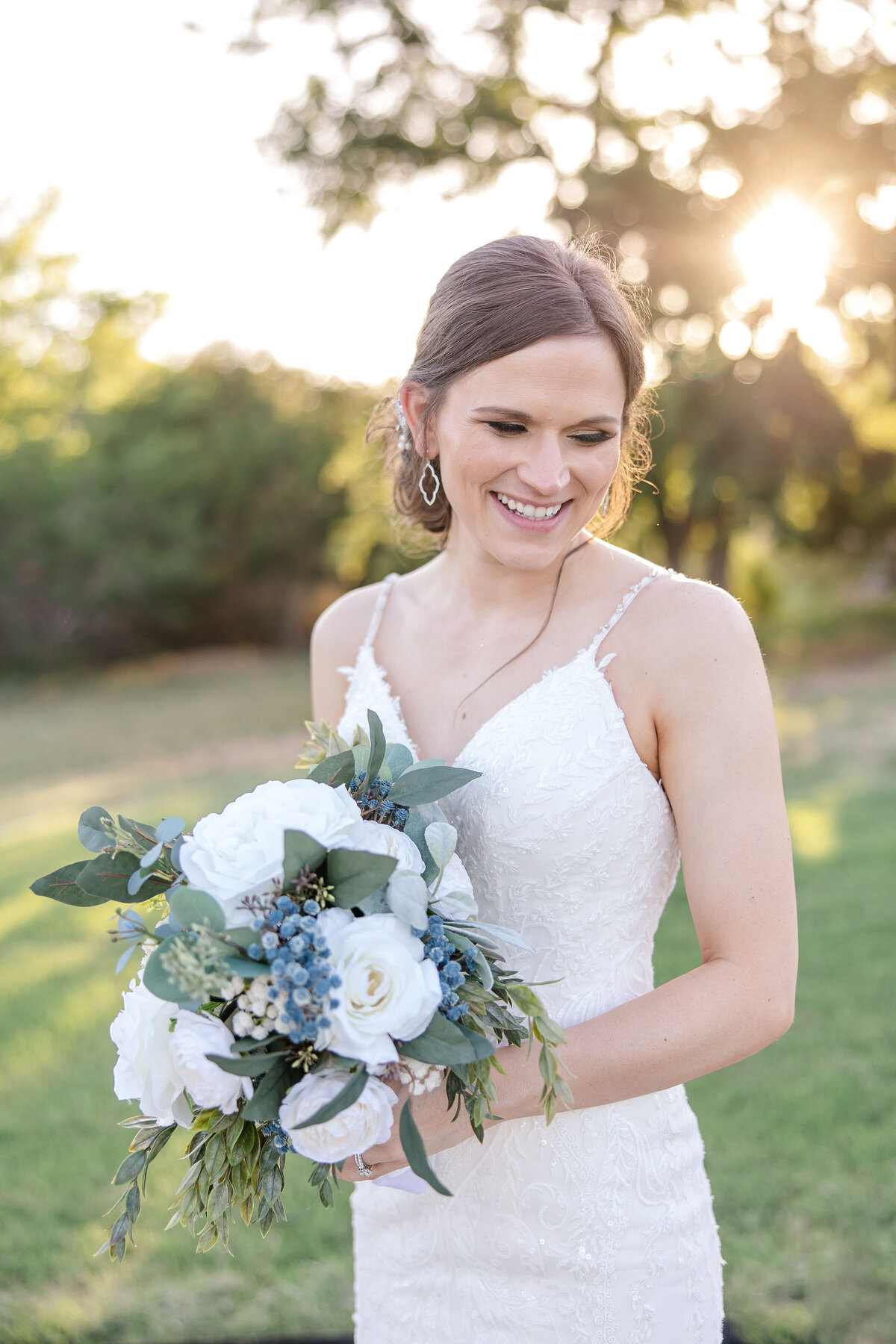 bride smiles while holding bouquet in sunset light near Austin Texas