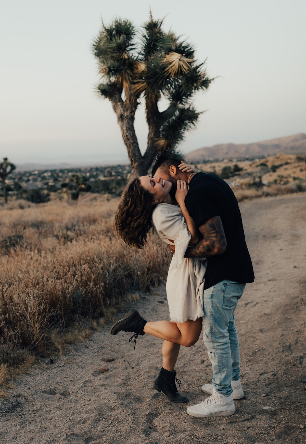 Couple stands together kissing in Joshua Tree California
