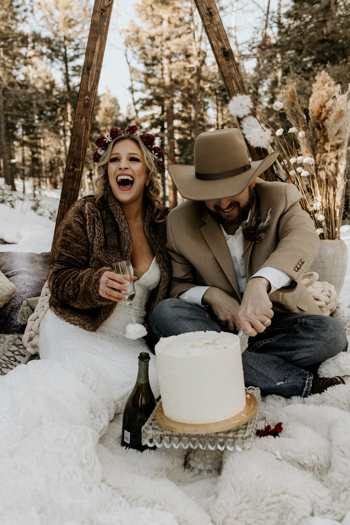 bride and groom eating their cake in the snow