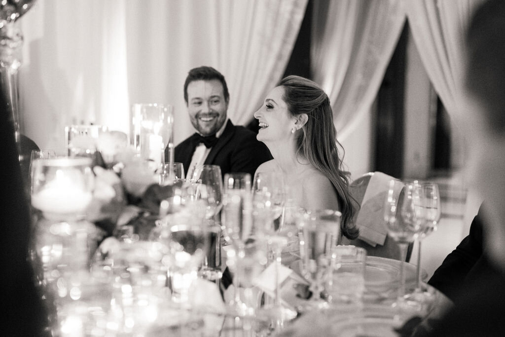 Black and white photo of the bride and groom at the table. 