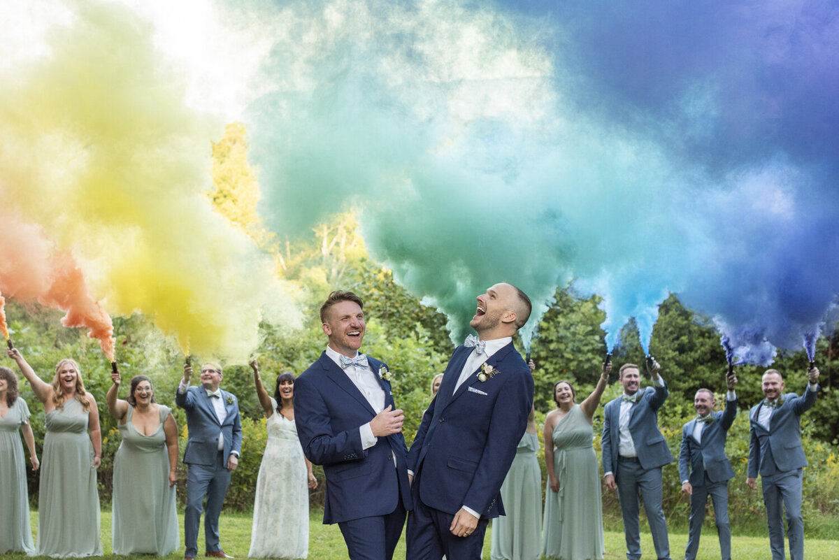 LGBTQ couple laughing during rainbow smoke bomb at Twisty Maple wedding