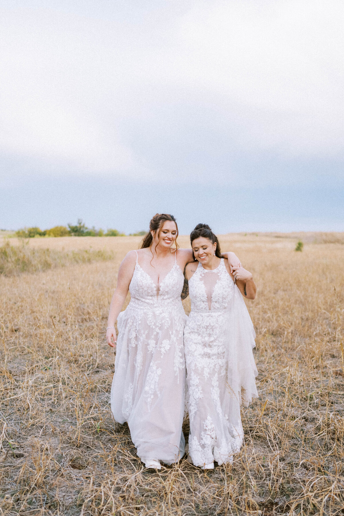 two-brides-walking-through-oklahoma-grasses