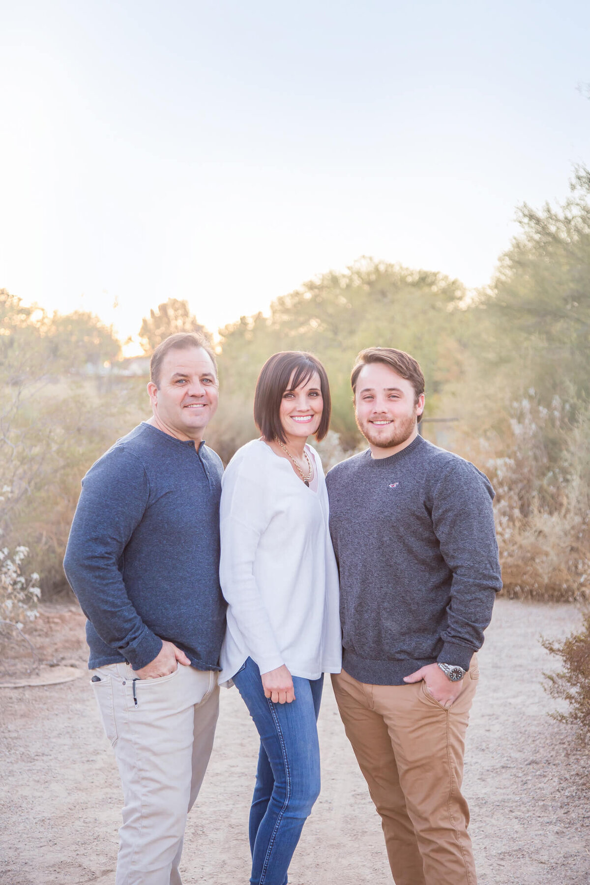 Couple and brown haired son in gray blue shirt on desert path