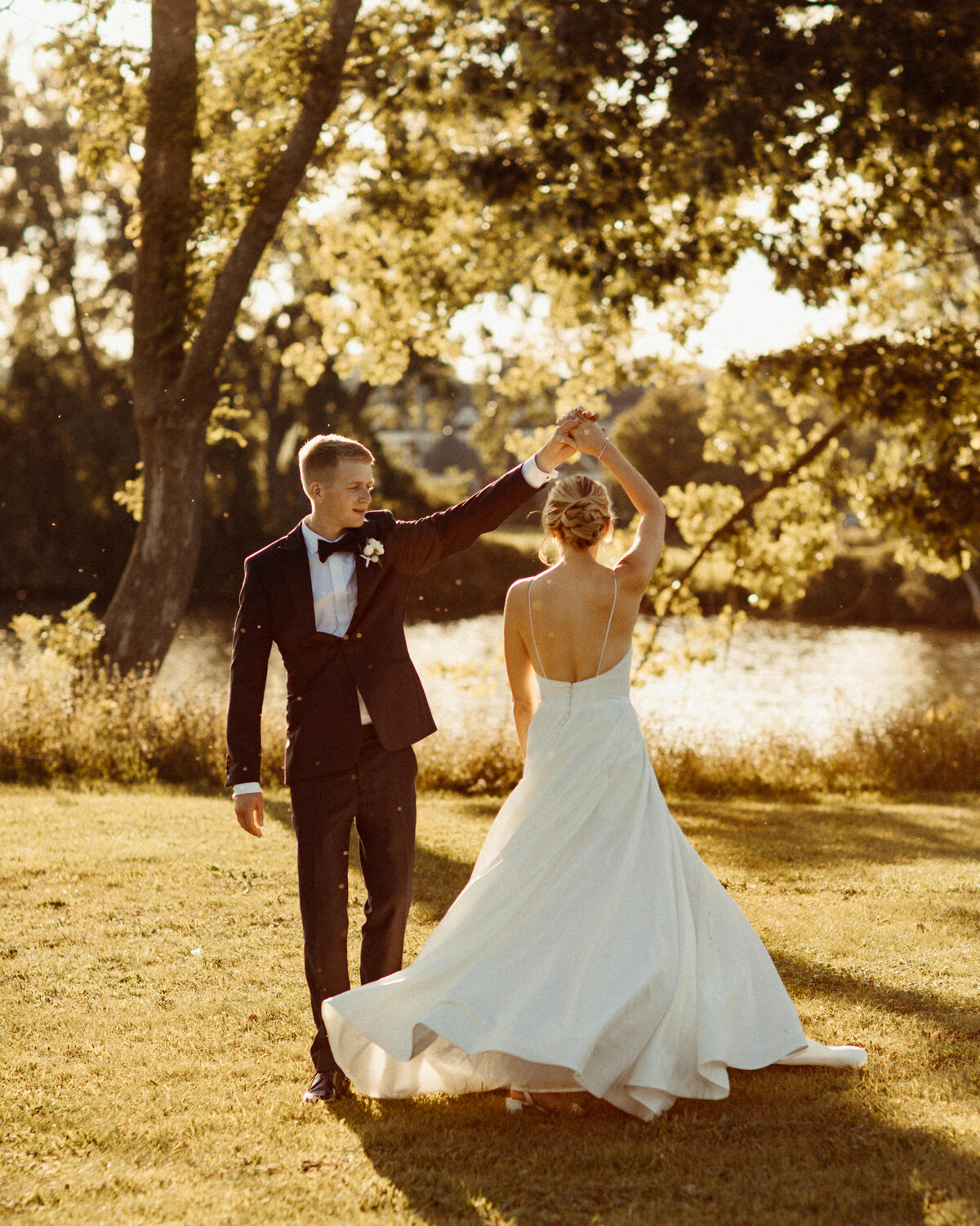 Groom spins bride in the sunlight at Skaneateles Country Club
