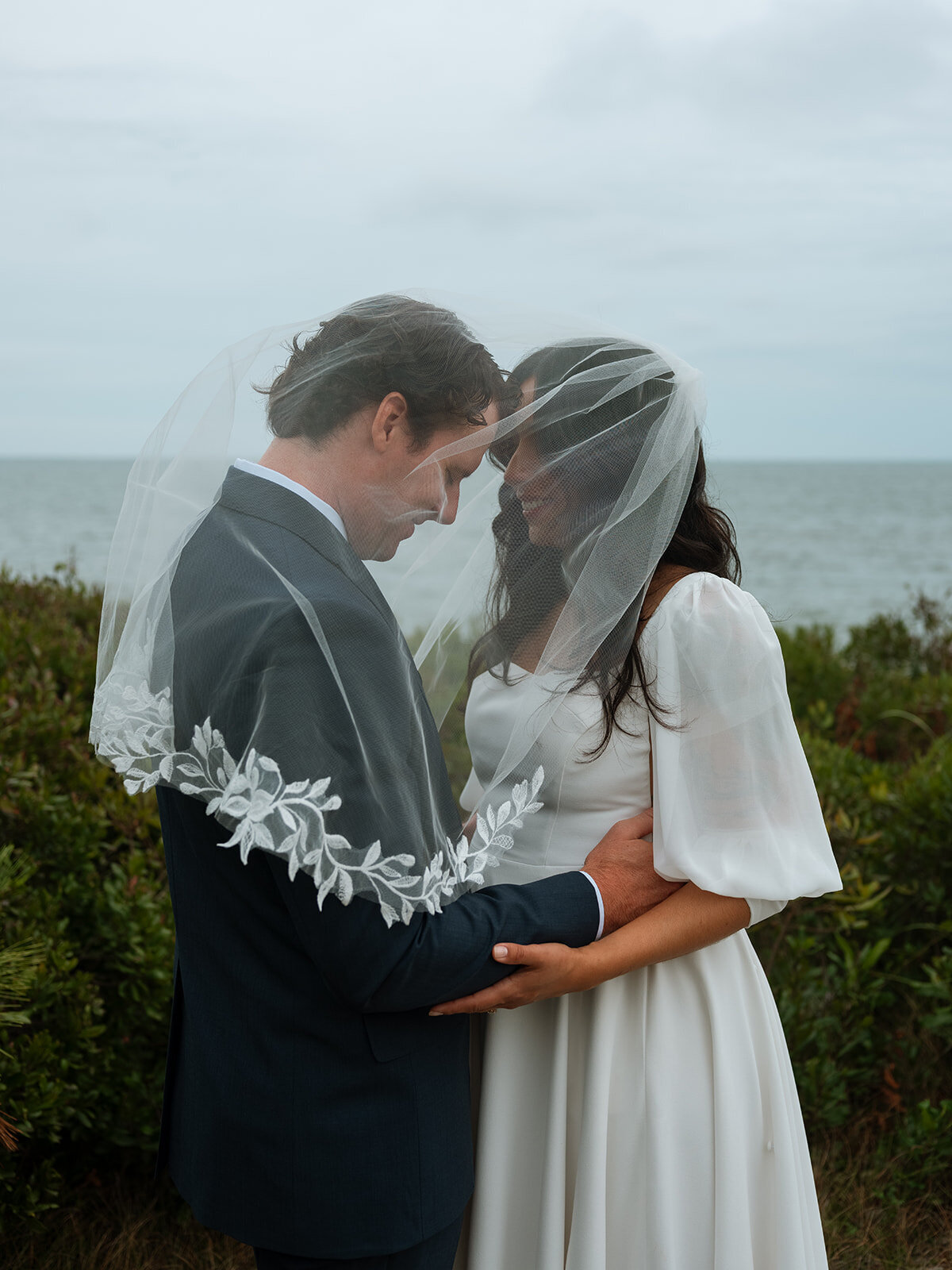 Bride and groom under veil at Cape Cod wedding