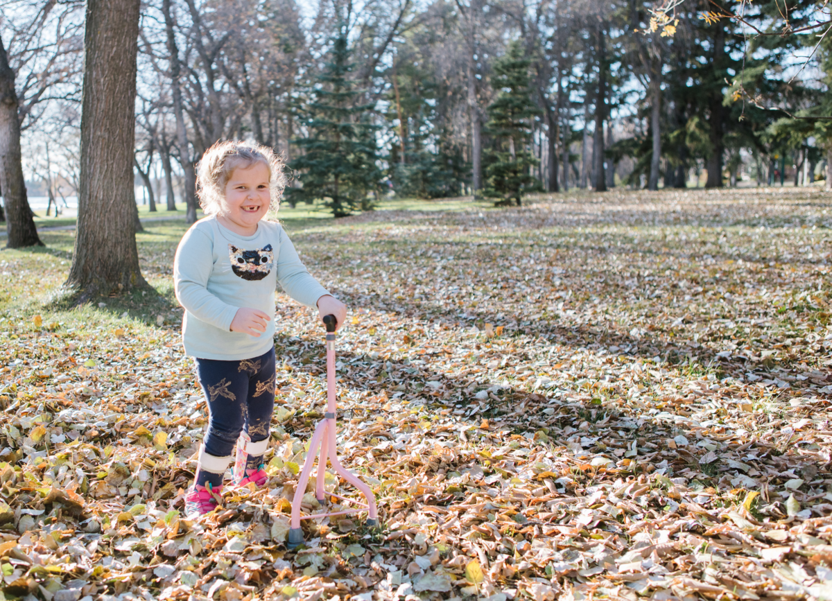 Child learning to walk with Pediatric Gait Trainer, a device that provides support to enable walking and standing.