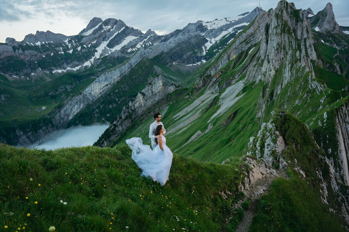 Couple standing majestically in mountains in Switzerland