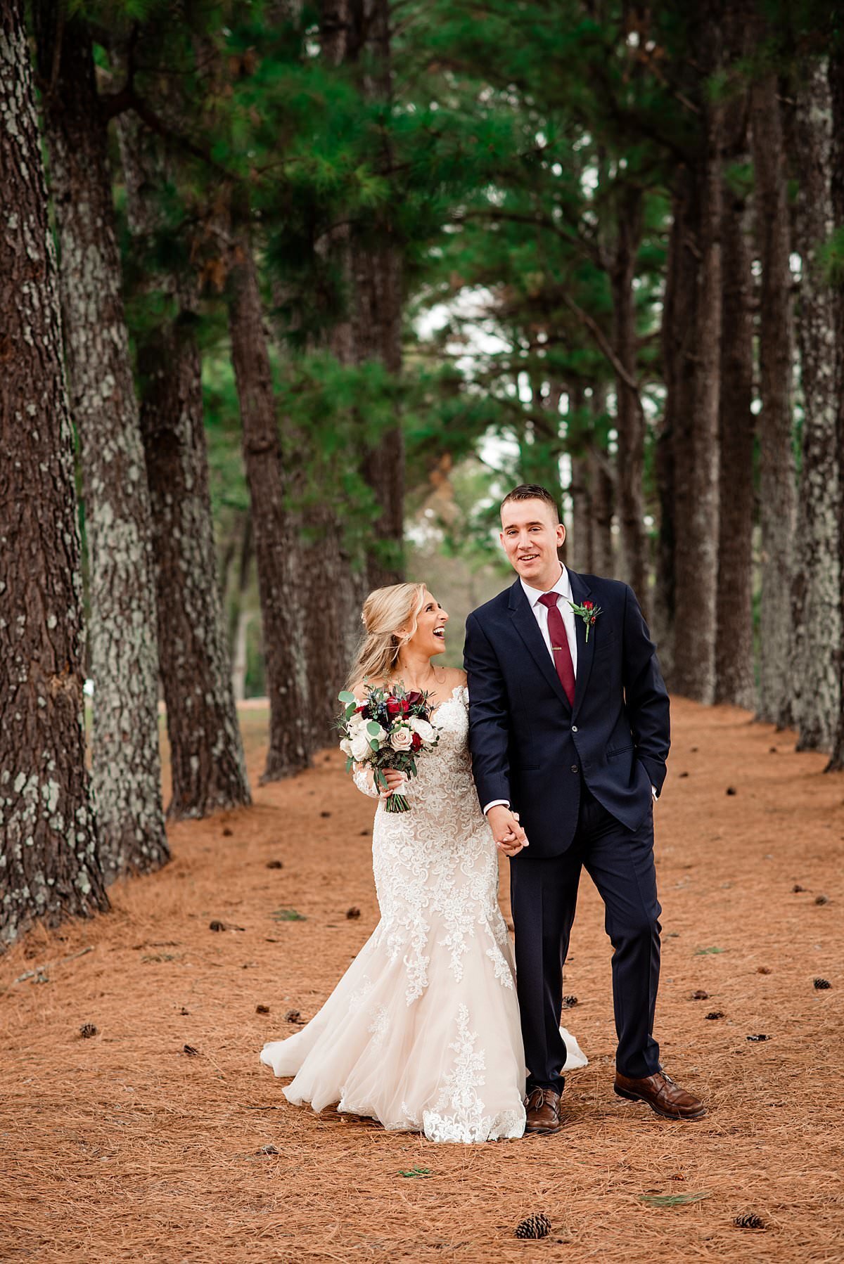 bride and groom strolling among tall pine trees