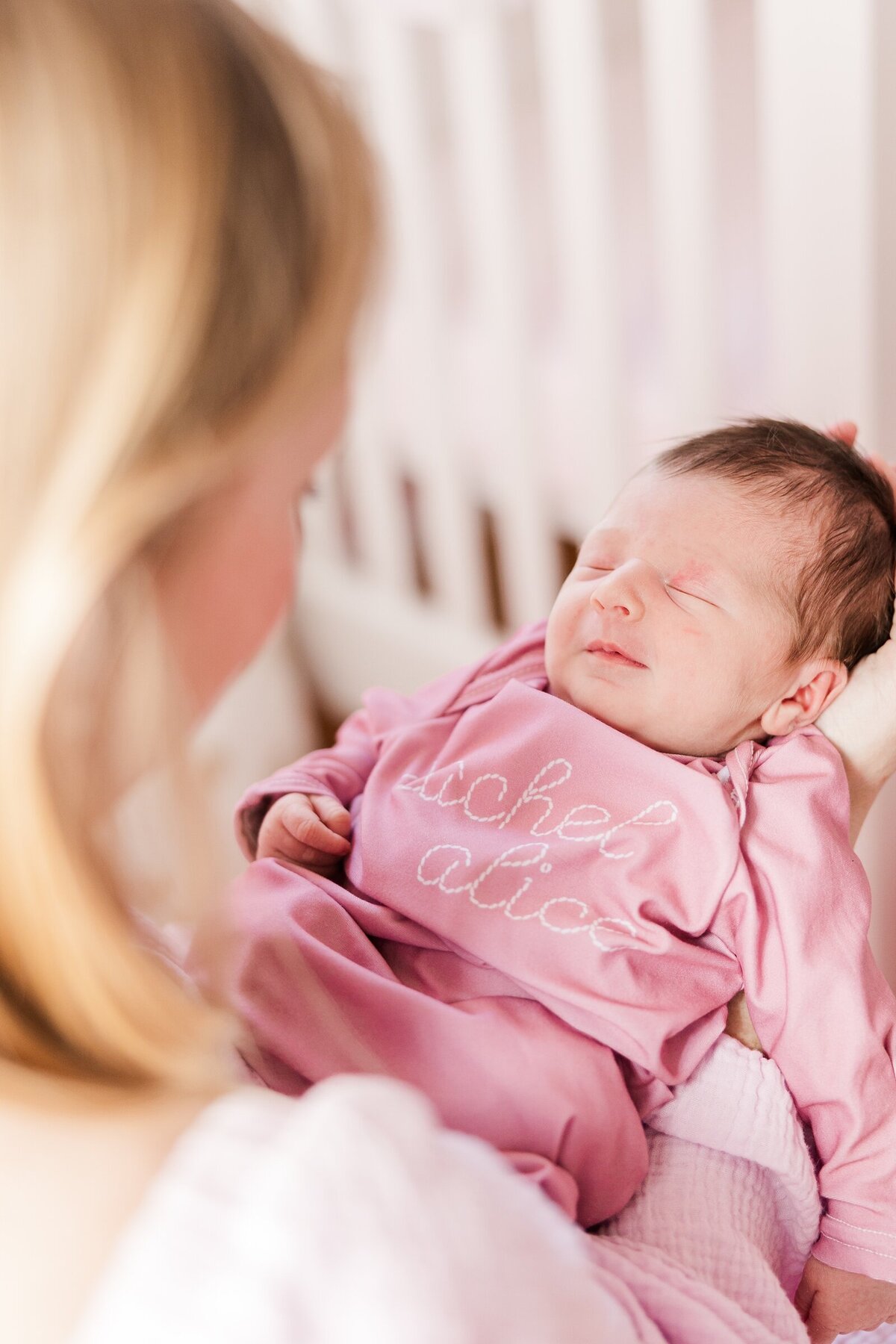 Mom looking down at her smiling newborn with Erin Thompson Photography