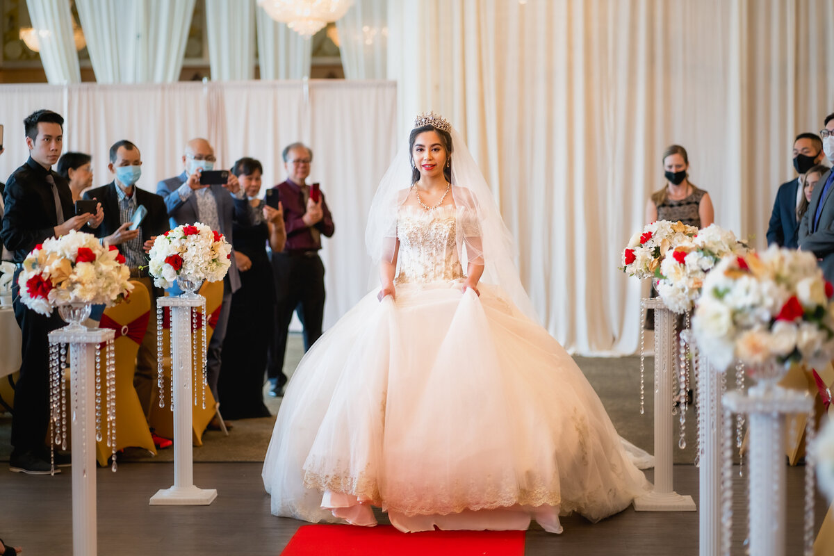 Bride in a western ball gown wedding dress walks down the aisle