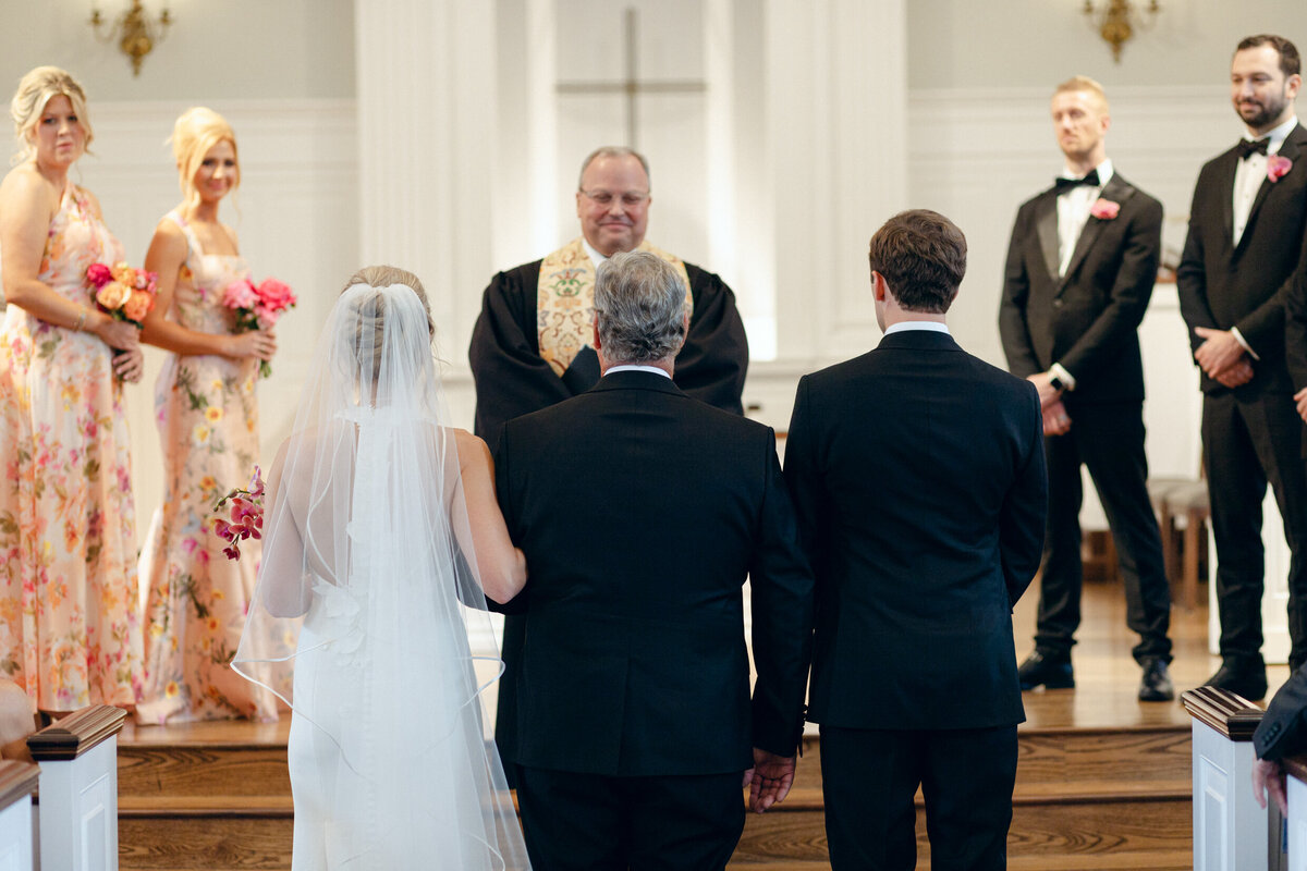 A wedding day photo of the bride walking down the aisle in her white wedding day dress