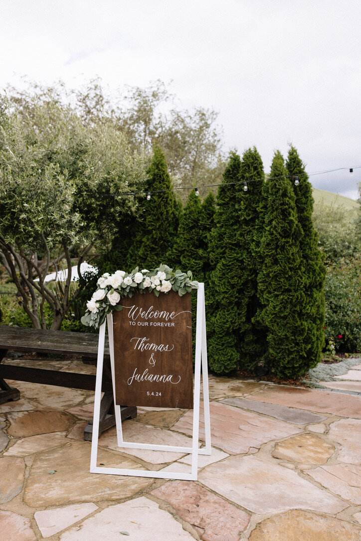 wood welcome sign, garland, tucked in flowers, garden roses, winery