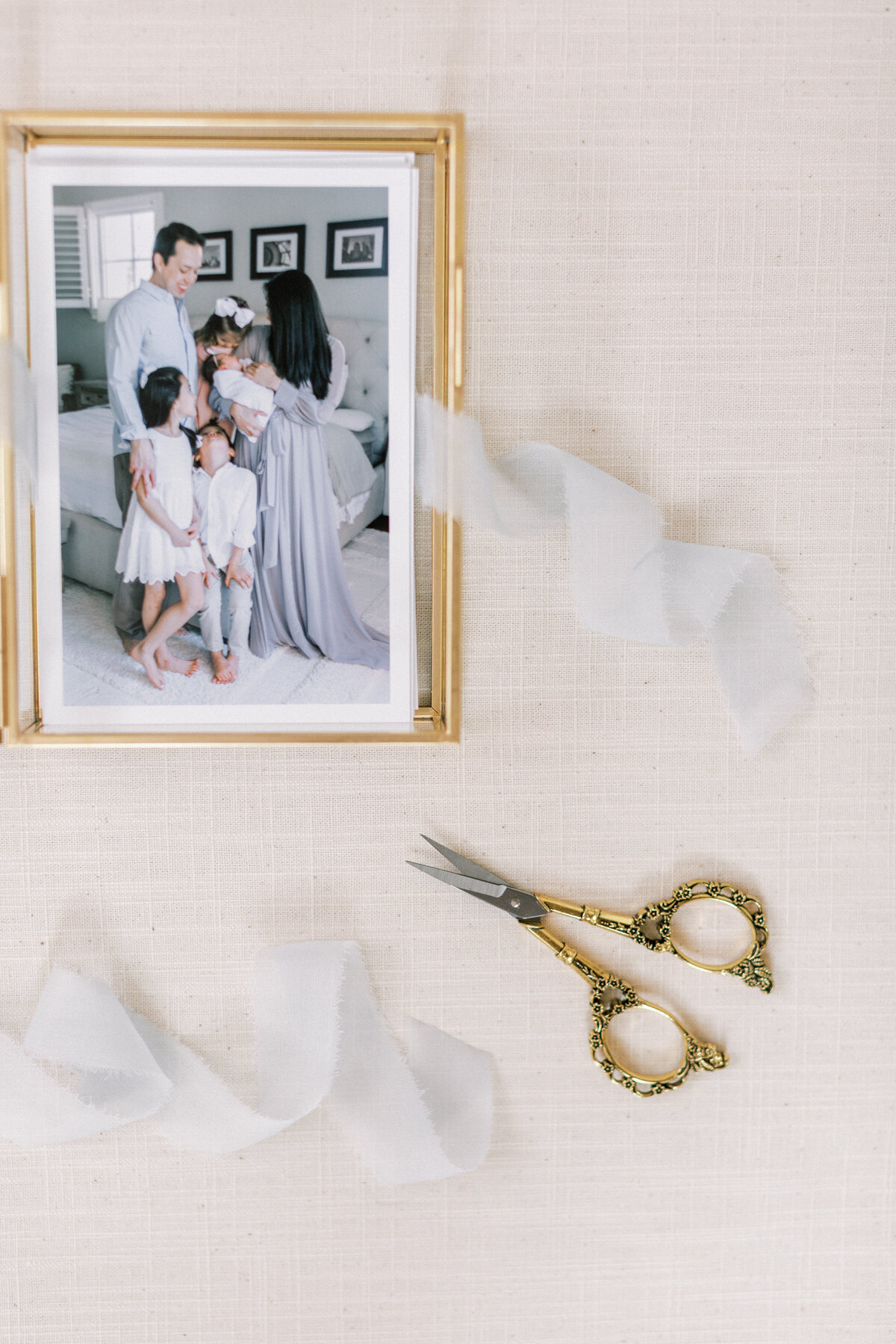 Glass box with proof prints and light blue ribbon and gold antique scissors