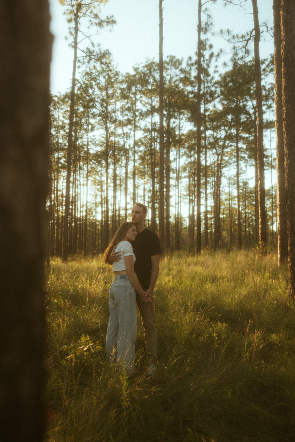 Couple posing for portraits in a forest.