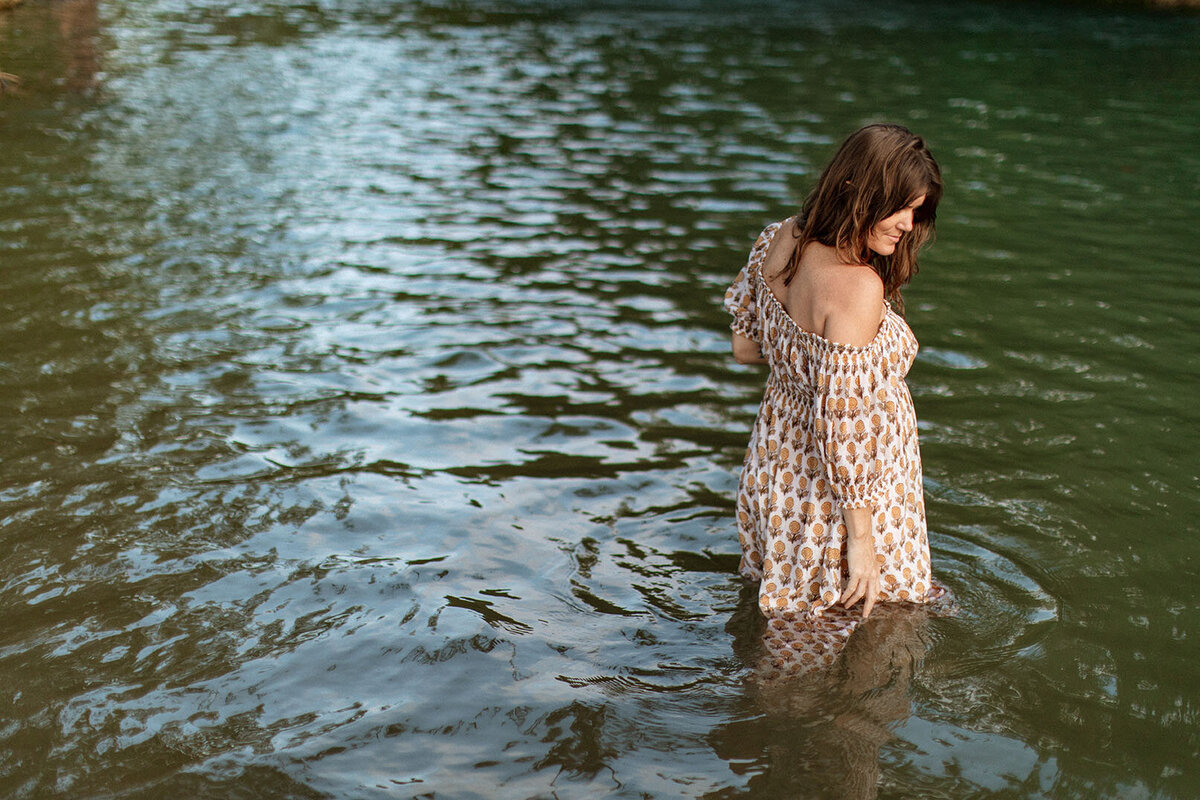 Maternity portrait of a pregnant woman standing in a river, photographed by San Antonio family photographer Sara James.